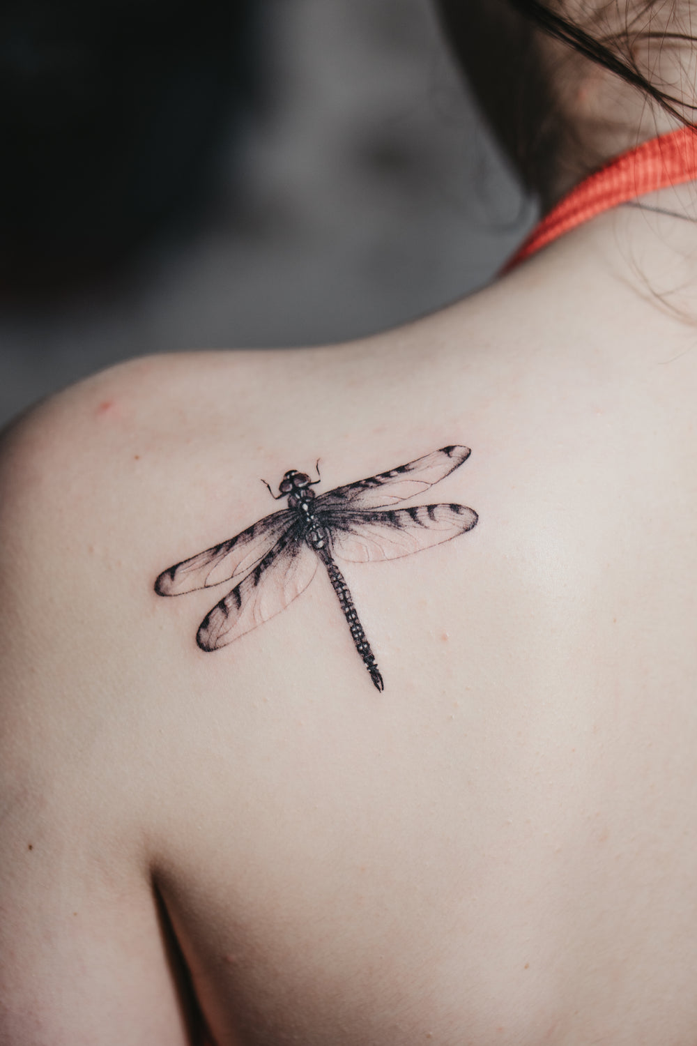 Dragonfly tattoo on a person's shoulder