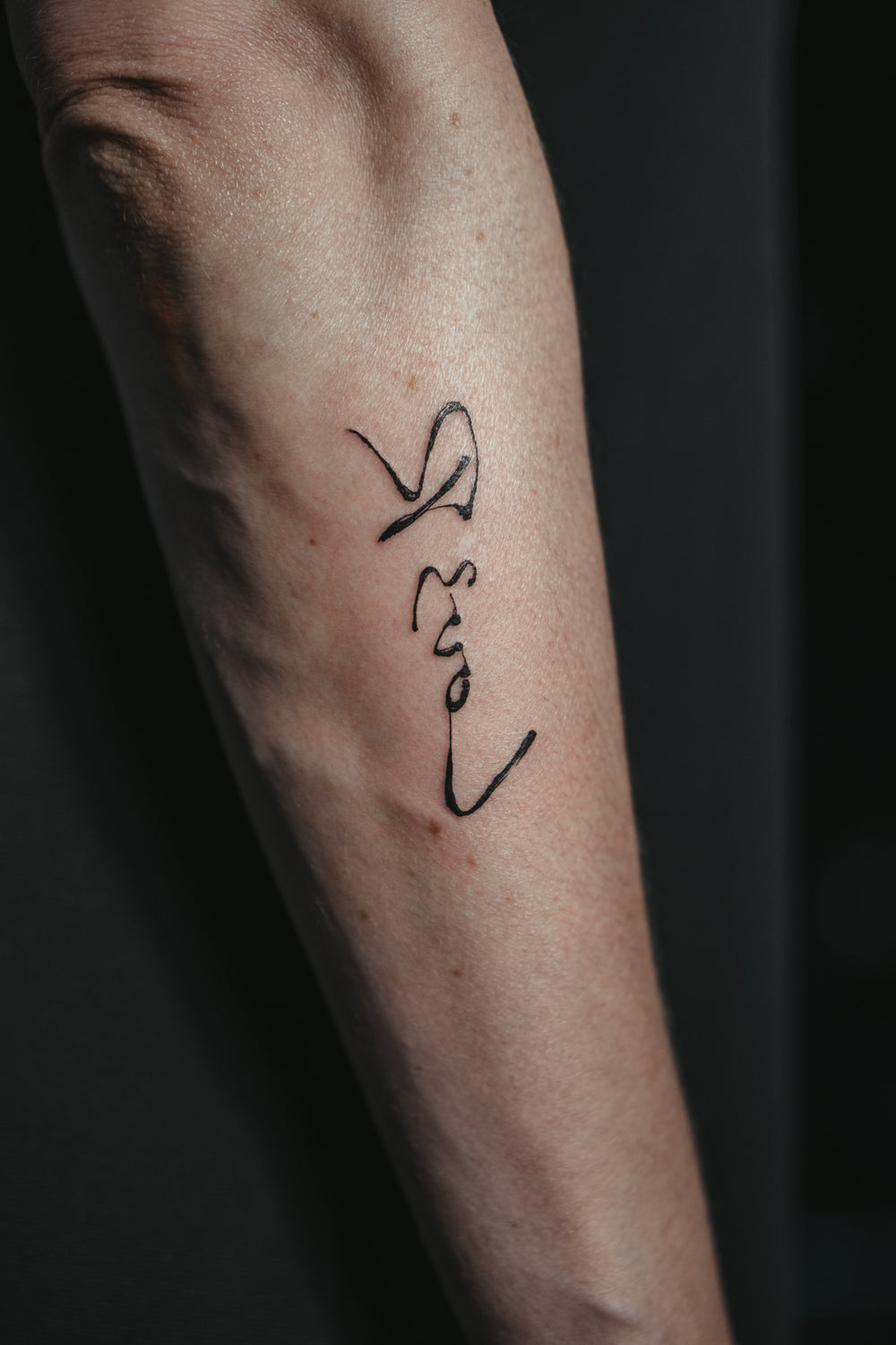 Tattoo on a person's arm with a dark background